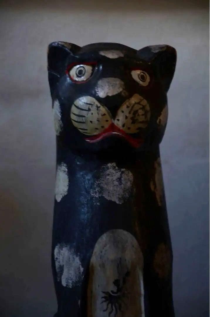 遠くを見る木彫りの猫